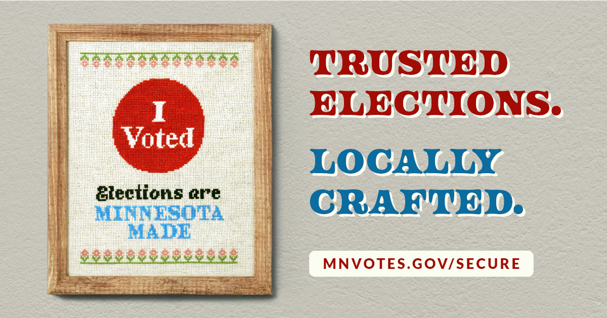 Framed cross-stitch art with an "I voted" sticker and the phrase Elections are Minnesota Made hanging on a wall next to the phrase Trusted Elections. Locally Crafted.